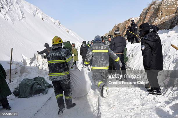 Army personnel and police officers work to dig out passenger carriages of a train that is trapped in snow on January 4, 2010 in Shangdu county in...