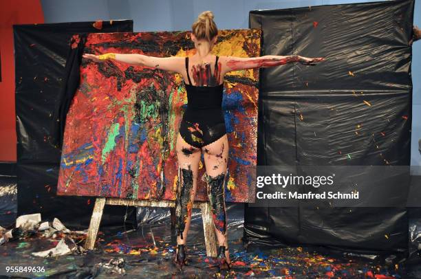 Model poses in front of a picture painted by Guenter Edlinger during the Pro Juventute Charity Fashion Show on May 7, 2018 in Vienna, Austria.