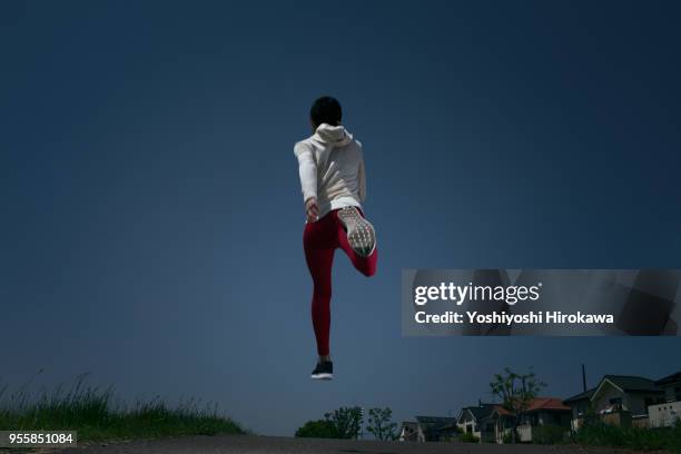 the woman runs the bank under the blue sky for health every morning - schwache beleuchtung stock-fotos und bilder