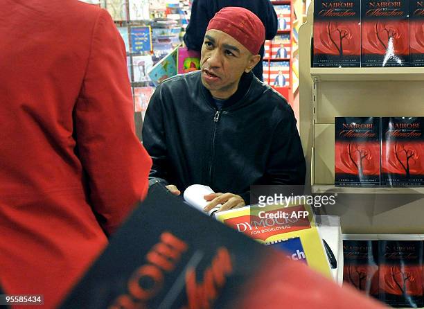 Mark Obama Ndesandjo, half-brother of US President Barack Obama, signs a copy of his new novel for a customer during the launch of his book 'Nairobi...