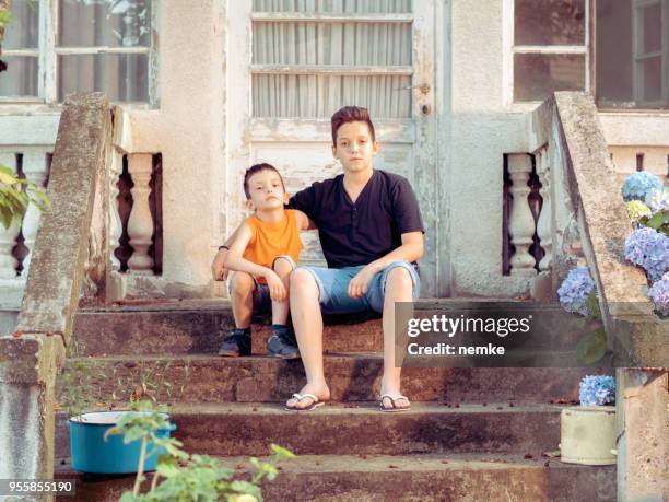 two brothers sitting outdoor - old brother stock pictures, royalty-free photos & images