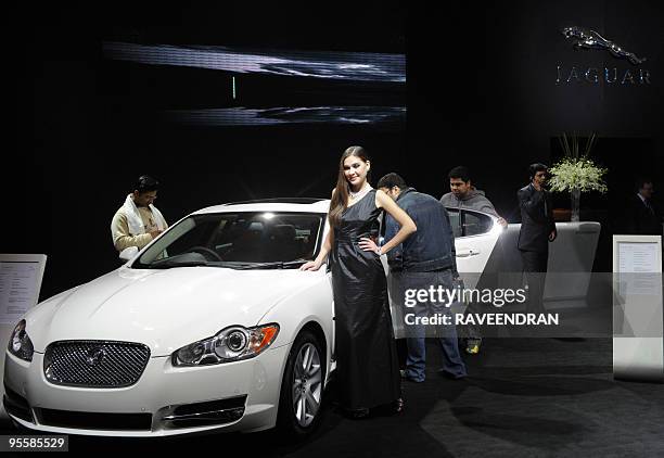 Model poses in front of a Jaguar XF 5.0 V8 car during the 10th Auto Expo in New Delhi on January 5, 2010. Global car manufacturers eyeing the...