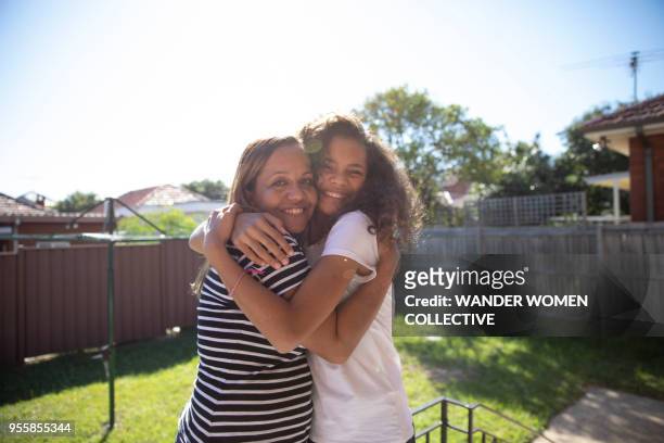 portrait of indigenous aboriginal australian mother and daughter in australian suburban backyard - オーストラレーシア ストックフォトと画像