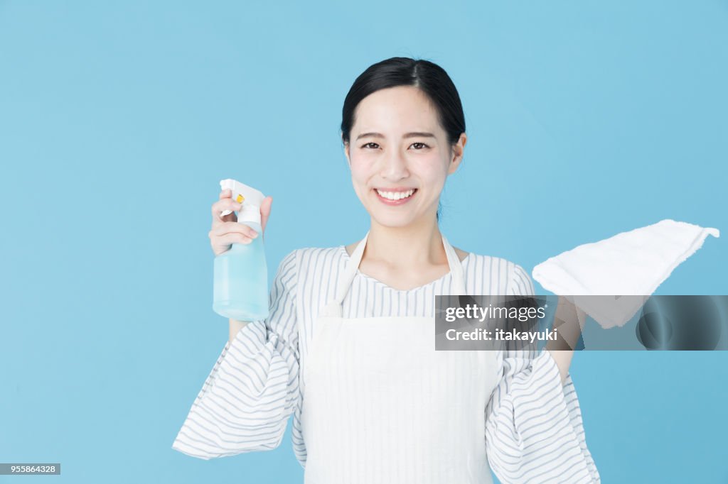 Porträt der jungen Asiatin Reinigung Bild auf blauem Hintergrund