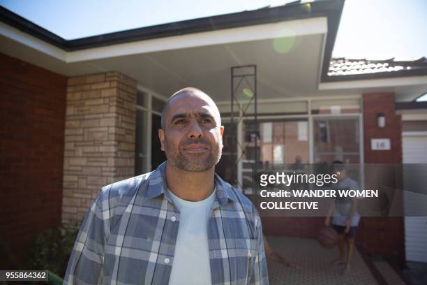 proud indigenous aboriginal australian man standing in front of his home - thisisaustralia stock-fotos und bilder