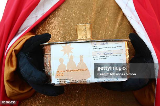 Carol singer, disguised as a oriental king, holds a tin box ahead of a collecting tour on January 5, 2010 in Germering, Germany. Sent by Catholic...