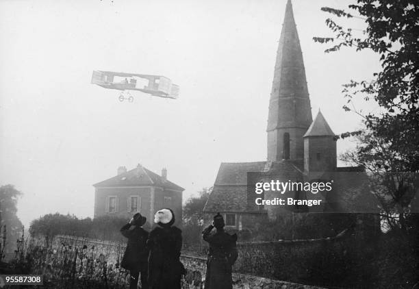 French aviation pioneer Henri Farman flying over a small village near Reims during his European cross country record flight of 26 kilometres from...