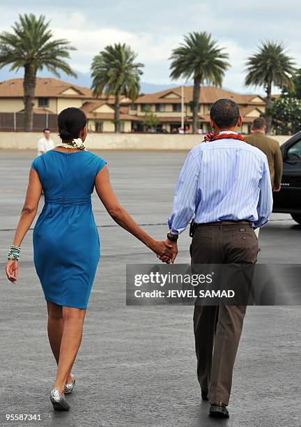 President Barack Obama and First Lady Michelle Obama walk to the motorcade after being greeted in the traditonal Hawaiian way upon their arrival at...