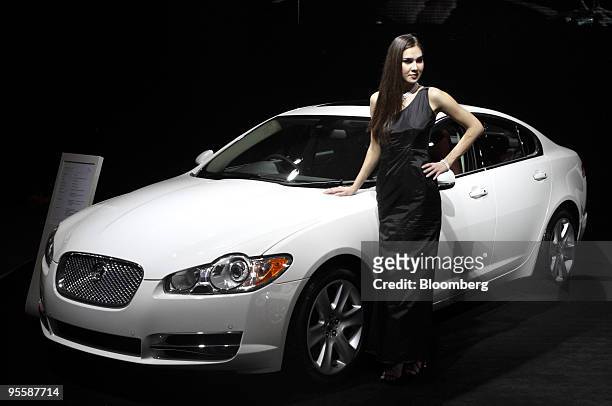 Model poses next to a Jaguar XF L automobile on display at the Auto Expo 2010 in New Delhi, India, on Tuesday, Jan. 5, 2010. Carmakers are...