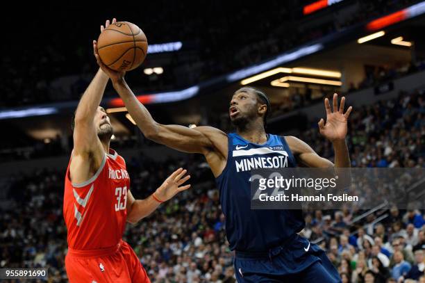 Andrew Wiggins of the Minnesota Timberwolves rebounds the ball against Ryan Anderson of the Houston Rockets in Game Three of Round One of the 2018...