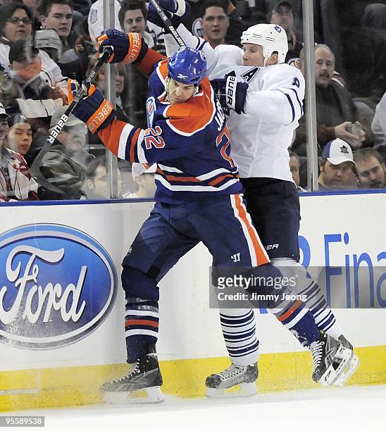 Jean-Francois Jacques of the Edmonton Oilers checks Mike Komisarek of the Toronto Maple Leafs during a NHL game on December 30, 2009 at Rexall Arena...