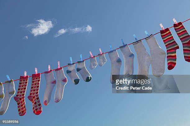 socks hanging on washing line - pair stock photos et images de collection