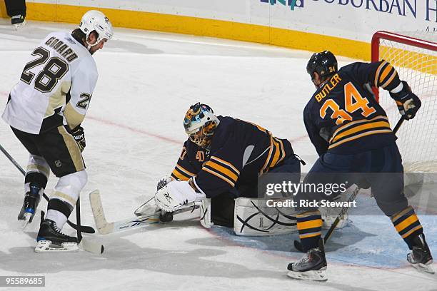 Patrick Lalime of the Buffalo Sabres makes a save as Chris Butler and Eric Godard of the Pittsburgh Penguins look on during the game at HSBC Arena on...