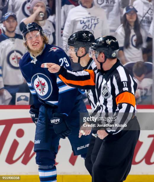 Patrik Laine of the Winnipeg Jets looks on as referee Kelly Sutherland points towards the penalty box during first period action against the...