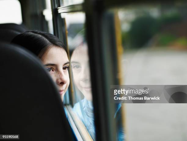 young female student looking out window of bus - tweenies stockfoto's en -beelden