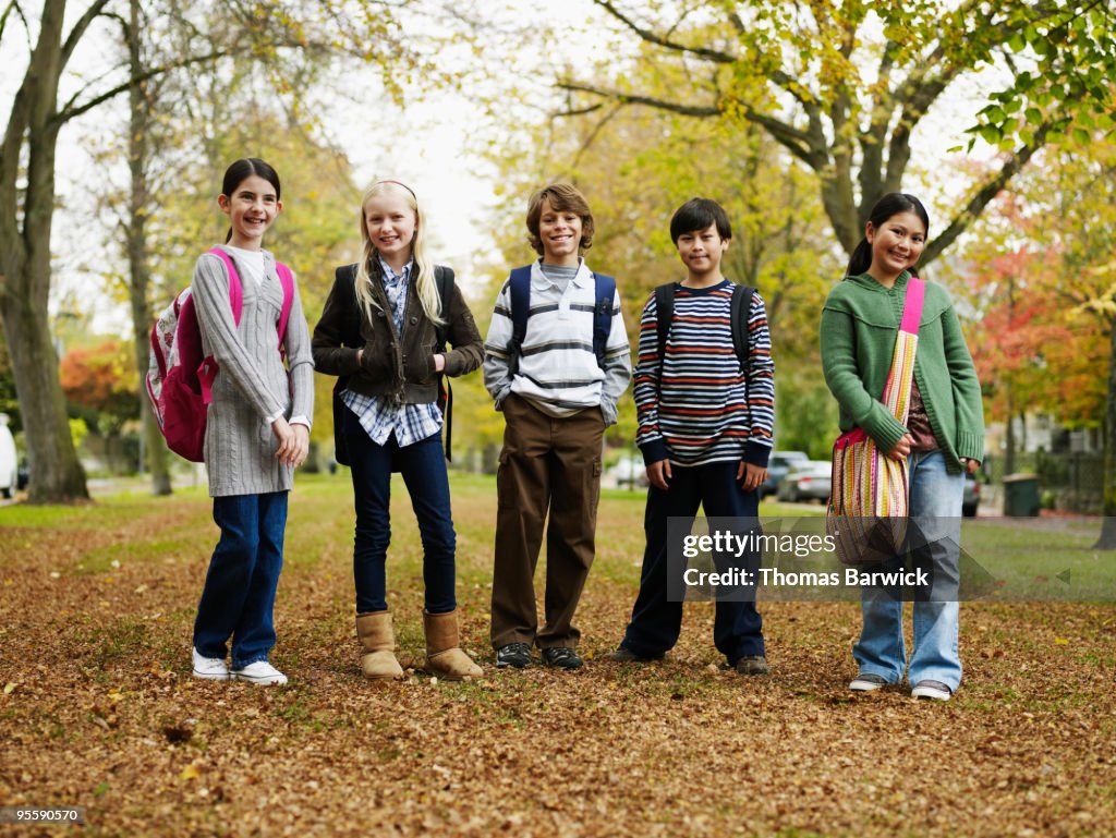 Group of young students wearing backpacks