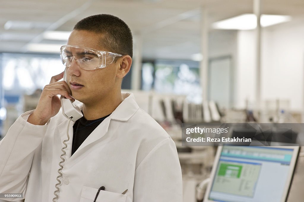 Lab worker listens on telephone