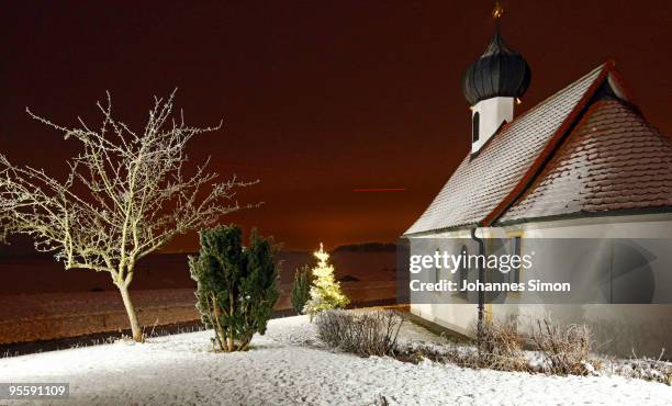 Snow covers the little chapel of Auing during dusk on January 5, 2010 near Steinebach am Woerthsee, Germany. Currently freezing temperature around...