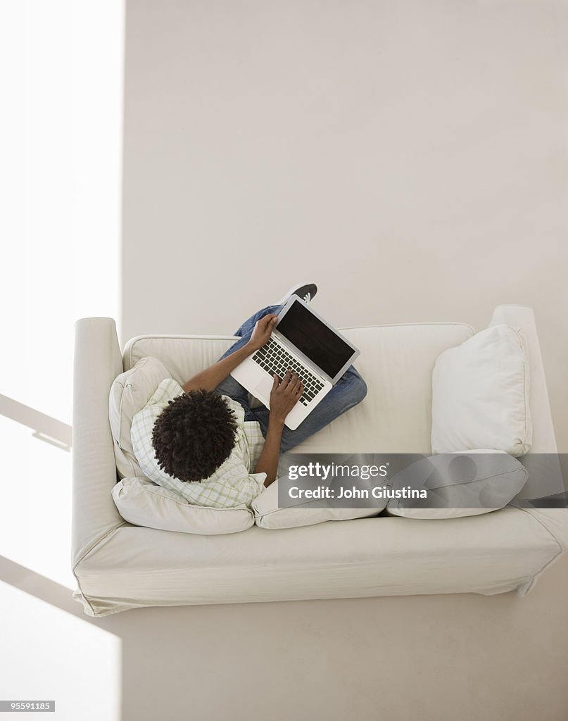 Man sitting with computer on couch.