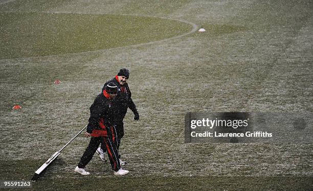 Groundstaff try and keep the pitch clear of snow during the Barclays Premier League match between Stoke City and Fulham at The Britannia Stadium on...