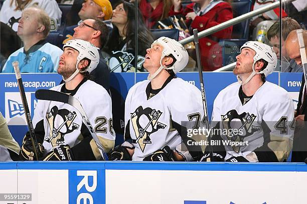 Eric Godard, Jay McKee, and Brooks Orpik of the Pittsburgh Penguins look at the scorebaord in a game against the Buffalo Sabres on December 29, 2009...