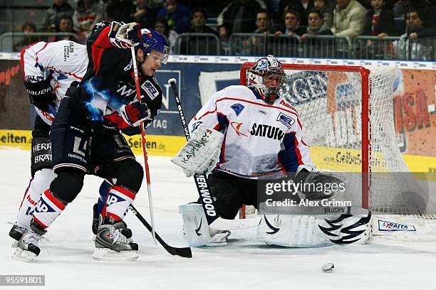 Goalkeeper Dimitri Paetzold of Ingolstadt is challenged by Justin Papineau of Mannheim during the DEL match between Adler Mannheim and ERC Ingolstadt...