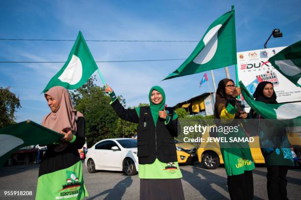 Malaysia's Islamic party supporters waves party flags at an intersection on the eve of the 14th general election in Alor Setar on May 8, 2018 .? -...