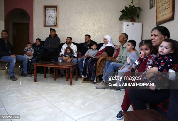 Palestinian refugee Khadija Sharkawi , 85-years-old, sits with her family members at her home in the Amari refugee camp near the West Bank city of...