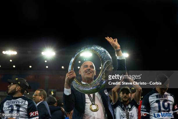Coach Kevin Muscat of Melbourne Victory celebrates by holding up the A-League trophy in front of fans after winning the 2018 A-League Grand Final...