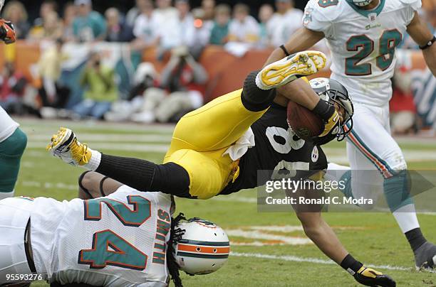 Hines Ward of the Pittsburgh Steelers gets tripped up after catching a pass during a NFL game against the Miami Dolphins at Land Shark Stadium on...