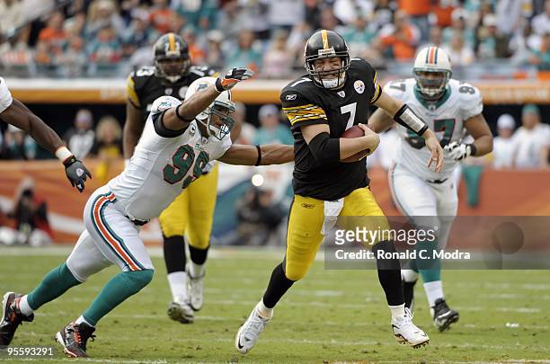 Quarterback Ben Roethlisberger of the Pittsburgh Steelers scrambles as Jason Taylor of the Miami Dolphins chases him during a NFL game at Land Shark...
