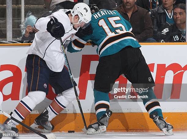 Ladislav Smid of the Edmonton Oilers battles for the puck along the boards with Dany Heatley of the San Jose Sharks during an NHL game on January 2,...
