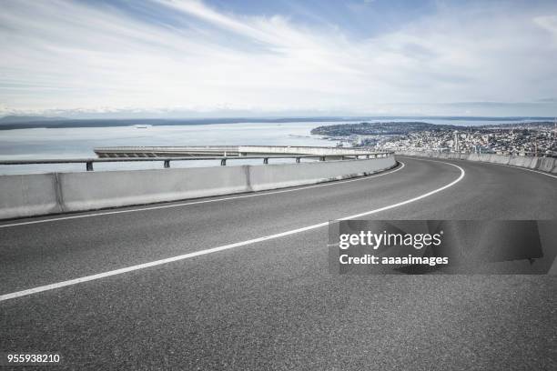 empty motorway with seattle bay on background against cloud sky - interstate road stock pictures, royalty-free photos & images