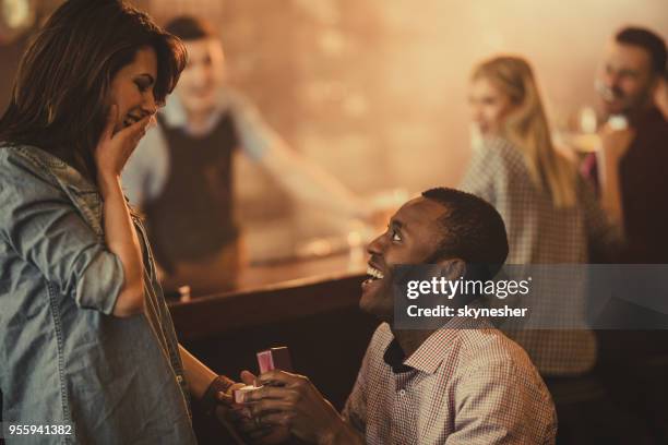 felice afroamericano che propone alla sua ragazza in un bar. - black women engagement rings foto e immagini stock