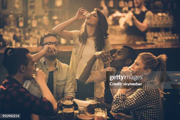 gruppen av unga vänner dricka tequila skott i en bar. - vodka bildbanksfoton och bilder