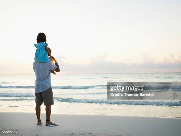 young girl riding on fathers shoulder at sunrise - 肩車 ストックフォトと画像