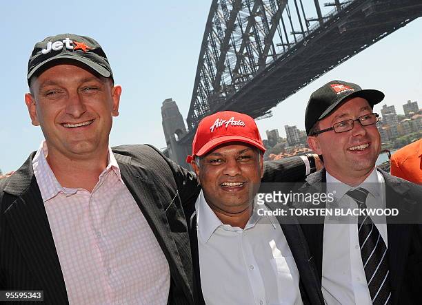 JetStar CEO Bruce Buchanan , AirAsia CEO Tony Fernandes , and Qantas CEO Alan Joyce embrace after announcing plans to slash costs and ticket prices...