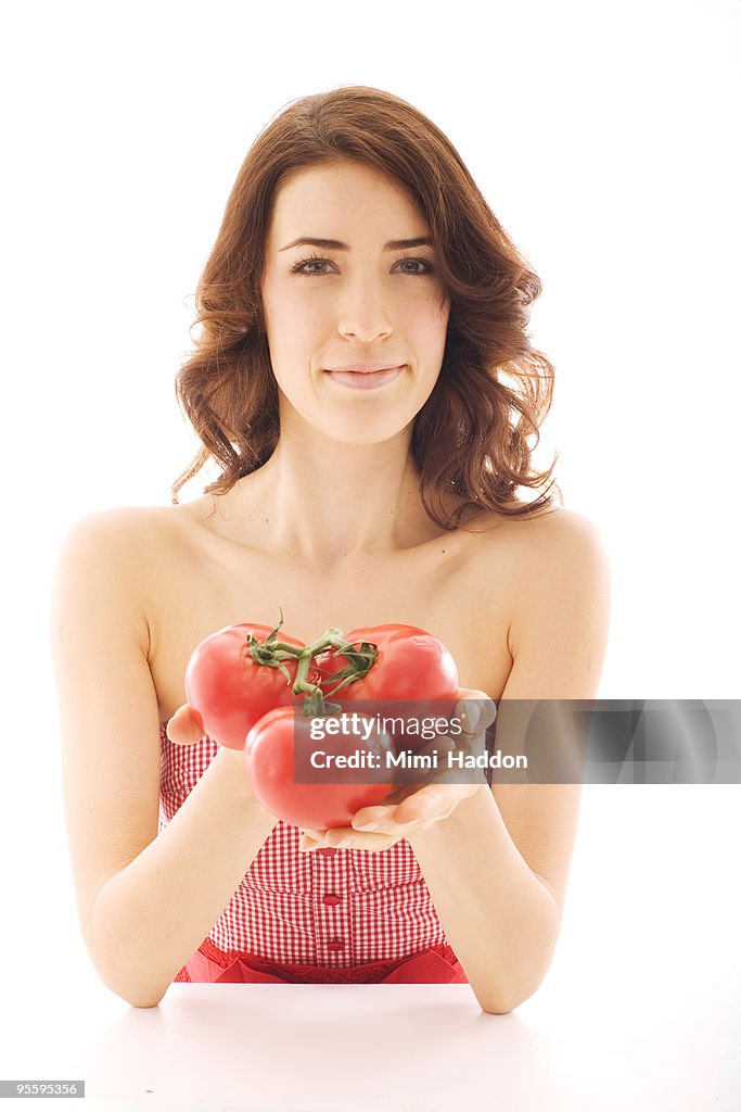 Woman in her 20's Holding Bunch of Tomatoes