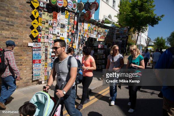 Popular stall selling metal street signs, old fashioned brands and music prints on Portobello Road Market in Notting Hill, West London, England,...
