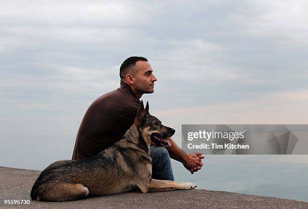 man and dog looking over tranquil lake, profile - escena de tranquilidad fotografías e imágenes de stock