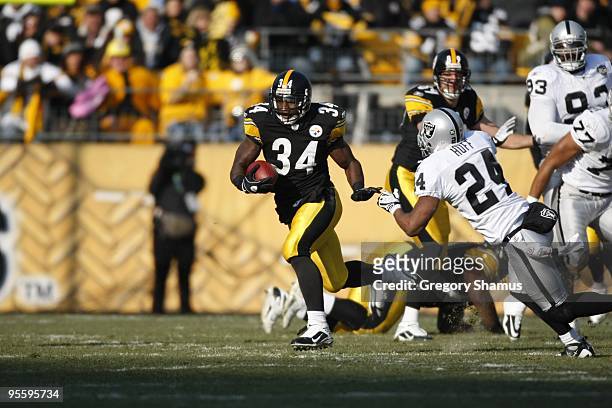 Rashard Mendenhall of the Pittsburgh Steelers carries the ball against Michael Huff of the Oakland Raiders on December 6, 2009 at Heinz Field in...