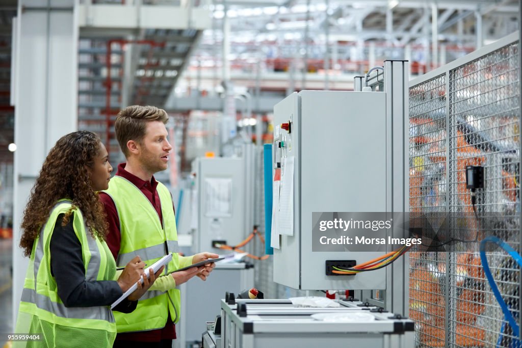 Car engineers standing in front of control panel