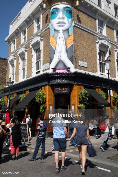 Scene outside Ukai gastropub on Portobello Road in Notting Hill, West London, England, United Kingdom. People enjoying a sunny day out hanging out at...