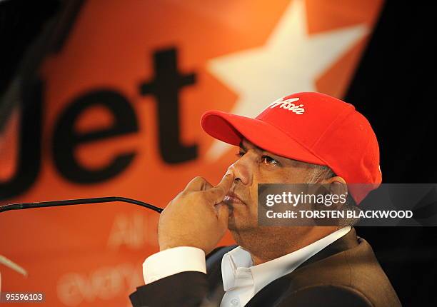 AirAsia CEO Tony Fernandes pokes his nose while announcing plans to slash costs and ticket prices by pooling with Australia's JetStar during a press...