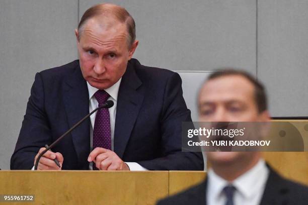 Russia's acting Prime Minister Dmitry Medvedev and President Vladimir Putin attend a session of the State Duma in Moscow on May 8, 2018. Russia's...