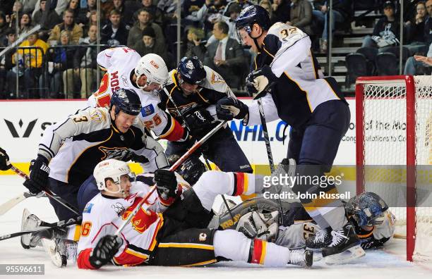 Wade Belak and Cody Franson of the Nashville Predators fight David Moss and Dustin Boyd of the Calgary Flames for the puck seconds before it trickled...