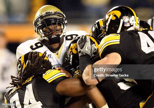 Quarterback Josh Nesbitt of the Georgia Tech Yellow Jackets is tackled by Adrian Clayborn of the Iowa Hawkeyes during the FedEx Orange Bowl at Land...