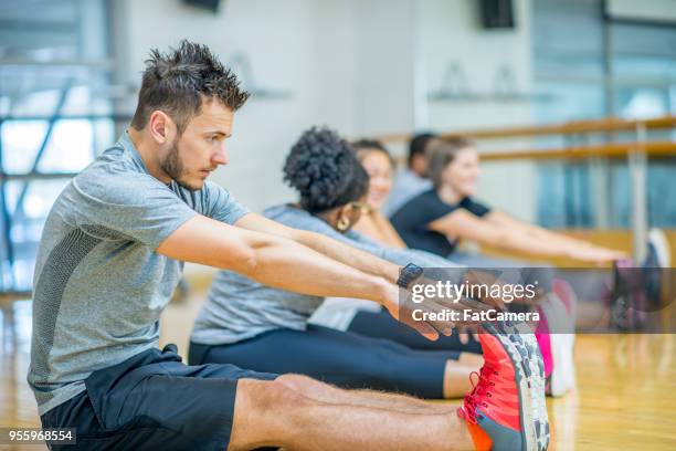 qui s’étend en cours de conditionnement physique - orteil photos et images de collection