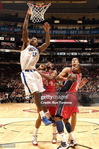 Amir Johnson of the Toronto Raptors goes to the basket against Trenton Hassell, Brook Lopez and Terrence Williams of the New Jersey Nets during the...