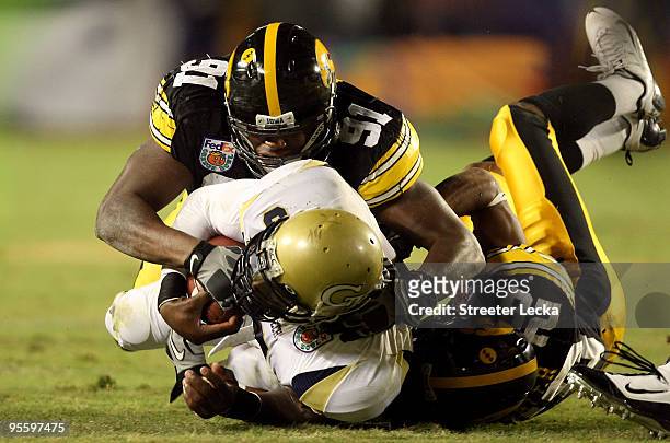 Josh Nesbitt of the Georgia Tech Yellow Jackets is tackled by Broderick Binns and Shaun Prater of the Iowa Hawkeyes during the FedEx Orange Bowl at...